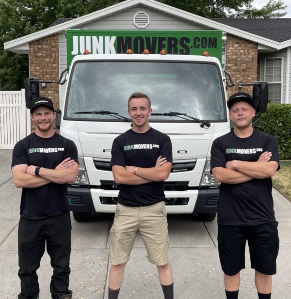 junk movers crew standing in front of truck ready to remove fence