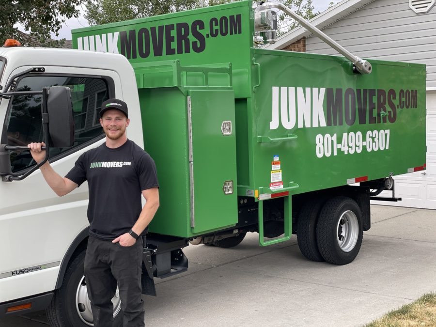 A Junk Movers professional posing with a junk removal truck